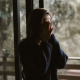 woman-standing-with-hands-on-face